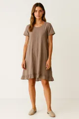 Vestido corto de algodón con efecto lavado, de corte holgado, cuello redondo, mangas cortas y detalle de volado en el ruedo.