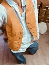 Chaleco de cuero color camel con doble botonadura y corte clásico.