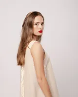 Vestido largo blanco de lino con escote en V y flecos de algodón en los bordes.