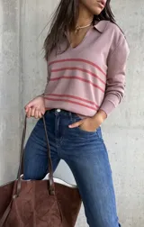 Sweater de tejido fino en color rosa, con diseño de rayas horizontales en tono más oscuro. Presenta cuello tipo polo con escote en V y mangas largas con puños ajustados.