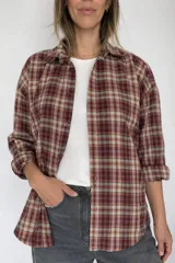 Camisa de manga larga con estampado a cuadros en tonos tierra, burdeos y beige. Presenta cuello clásico, cierre frontal con botones y corte holgado.