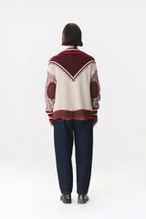Cardigan de punto con diseño multicolor, cuello tipo polo con rayas, cierre frontal con botones y bolsillos aplicados. Presenta mangas con trama trenzada, coderas en contraste y bordado de la marca en el frente.