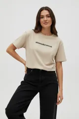 Remera de algodón color beige con cuello redondo y manga corta. Presenta un estampado centrado con la palabra "Misunderstood" en letras negras.