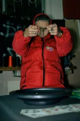 Campera puffer roja con capucha, cierre frontal con cremallera y logo bordado en el pecho.