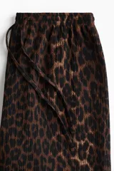 Pantalón de punto de corte holgado con piernas amplias y tiro alto, cintura elástica con cordón de ajuste y estampado animal print de leopardo.