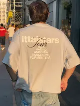 Remera celeste de corte recto con estampado en la espalda que incluye el texto "Itta Stars Tour" y una lista de ciudades: Ibiza, Madrid, Andorra, Barcelona y Formentera.