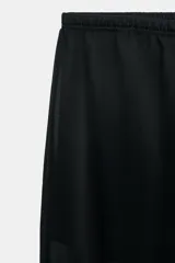 Pantalón negro de tiro alto con cintura elástica y pierna recta. Confeccionado en tela semitransparente, con forro corto interior a tono.