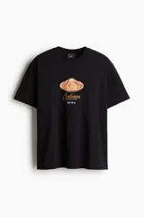Remera negra de punto de algodón con cuello redondo, mangas cortas y hombros caídos. Presenta un estampado frontal con la imagen de un plato de pasta carbonara y la inscripción "Carbonara Roma".