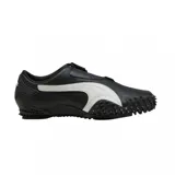 Championes Puma modelo Mostro Perforated, de diseño aerodinámico en color negro con detalles en blanco. Presentan una superficie de cuero perforado, cierre de velcro y una suela característica con relieve de tachas que se extiende hacia la puntera.