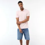 Remera tipo polo de manga corta en color rosa claro, con cuello clásico y cierre frontal de botones.
