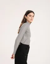 Polera gris de rib elastizado con brillos, cuello alto y mangas largas.