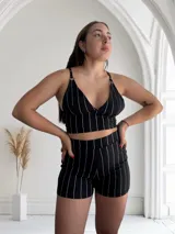 Short de tiro alto con diseño de rayas verticales plateadas sobre fondo negro, confeccionado en tela elástica.