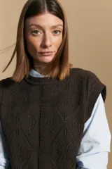 Chaleco tejido color marrón oscuro, con cuello redondo y diseño de rombos calados en el frente.