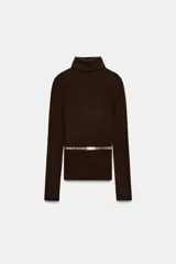 Jersey de punto liso confeccionado en 100% lana, con cuello subido y manga larga. Incluye un cinturón fino integrado en la cintura con hebilla metálica.