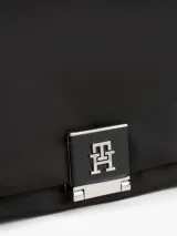 Cartera negra con acabado liso, solapa con cierre de pinza metálico con el monograma TH. Cuenta con dos compartimentos principales, un compartimento con cremallera y dos correas extraíbles: una delgada y una ancha tejida ajustable.