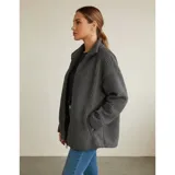 Campera de corderito color blanco, con cuello alto, cierre frontal completo y un bolsillo en el pecho con cierre.