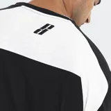 Remera de algodón con corte oversize, diseño bicolor en negro y blanco con paneles laterales en contraste. Presenta logo bordado en el frente y en la espalda.