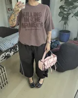 Remera oversize color beige con efecto acid wash y estampa frontal en marrón con la frase "Killing In The Name Of".