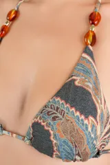 Top de bikini de corte triangular con tirantes ajustables para atar al cuello y la espalda. Cuenta con estampado estilo paisley en tonos oscuros y cuentas acrílicas en los breteles.