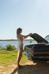 Top corto de diseño asimétrico con escote cruzado y mangas cortas, confeccionado en tela con estampado geométrico multicolor en tonos azul, verde y ocre.