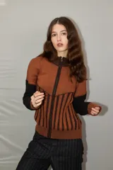 Campera de punto con cierre frontal, diseño bicolor en tonos bordó y rojo, con mangas largas y textura combinada de tejido liso y acanalado.