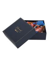 Pañuelo de seda con estampado abstracto y colorido sobre fondo rosa pálido. El pañuelo está anudado en el centro y presenta texto repetido en los extremos.