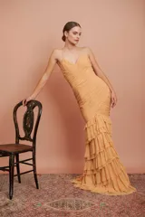 Vestido largo de fiesta color tostado, con escote en V, tirantes finos, cuerpo drapeado y falda sirena con múltiples volados en cascada.