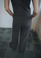 Pantalón de vestir tiro medio con diseño wide leg, pinzas en la parte delantera, bolsillos laterales y cierre con botón, gancho y cremallera.