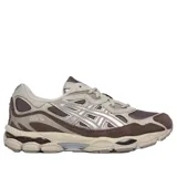 Championes Asics modelo Gel-Nyc, en combinación de tonos marrón, gris y detalles plateados. Presentan diseño técnico con malla transpirable, refuerzos sintéticos y suela amortiguada.