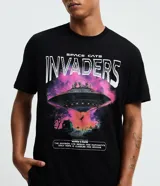 Remera negra de algodón con cuello redondo, manga corta y estampado gráfico frontal con temática espacial y de gatos ("Space Cats Invaders").