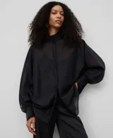 Camisa amplia semitransparente color negro, con cuello chimenea, manga japonesa con puño y botonadura frontal oculta.