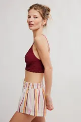 Bralette de encaje negro con copas triangulares, escote festoneado, tirantes finos regulables y banda inferior elastizada.