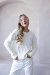 Sweater color crema de punto con diseño de ochos y flores bordadas. De corte holgado y mangas largas.