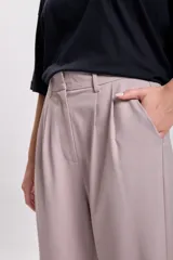 Pantalón de vestir color visón, de corte carrot, con pinzas en la cintura y bolsillos laterales.