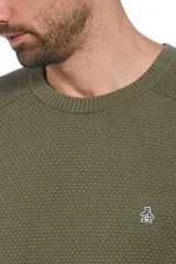 Sweater de punto con textura tipo panal en color verde oliva, de cuello redondo y manga larga. Presenta el logo de la marca bordado en el pecho.