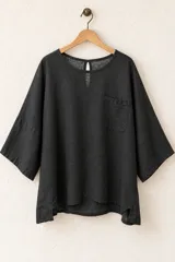 Remera de algodón color verde militar, de corte holgado, con mangas cortas amplias, cuello redondo y un bolsillo aplicado en el pecho.