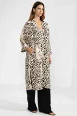 Camisa larga de lino color crema con estampado animal print que combina patrones de leopardo y cebra, cuello en V, cierre frontal con botones y mangas tres cuartos.