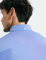 Camisa de manga larga en color azul, con cuello abotonado y bolsillo frontal en el pecho.