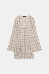 Vestido corto de algodón con estampado de cuadros en tonos beige y marrón. Presenta escote en pico, manga larga con corte evasé y bajo con volantes. Incluye cierre frontal con ganchos metálicos y cremallera lateral oculta.