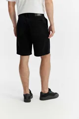 Bermuda de cinco bolsillos color negro con líneas rectas y estructura relajada.