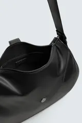 Bandolera negra de cuero sintético con correa ajustable para el hombro y cierre con solapa con hebilla decorativa.