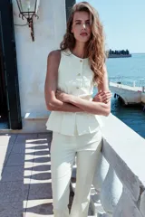 Pantalón tobillero de tiro medio, color blanco, con diseño flare o evasé en el bajo y bolsillos delanteros con cremallera oculta.