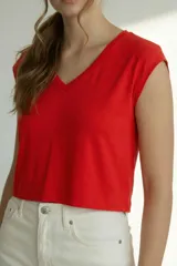 Remera de manga corta color rojo vibrante, con escote en V y corte cropped. Presenta un detalle de costura vertical central en el frente.