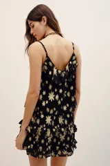 Top de tirantes finos en tejido jacquard negro con estampado floral metalizado dorado, escote con volados y diseño fluido.