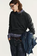 Jersey de punto con cuello redondo y manga larga, con acabados en rib ancho a tono y bajo asimétrico.