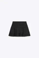 Falda pantalón de tiro medio en color negro, con diseño de pliegues en la parte superior y volantes en el ruedo. Cuenta con cierre lateral.