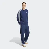 Buzo Adidas de cuello redondo con corte holgado, color azul marino. Presenta las icónicas tres rayas blancas en los hombros y mangas, y el logo del trifolio bordado en el pecho.