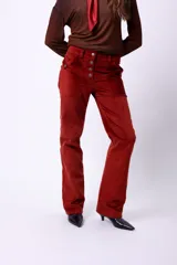Pantalón de pana color bordó, de corte recto, con botones frontales y bolsillos laterales.