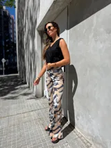 Pantalón de tejido con textura y caída suave, con estampado abstracto en tonos marrones y negros.