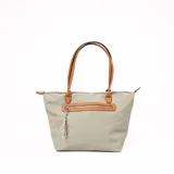 Cartera tipo tote de tela color verde con detalles en cuero sintético color marrón. Tiene cierre superior y un bolsillo frontal con cierre. Las asas son de cuero sintético color marrón.